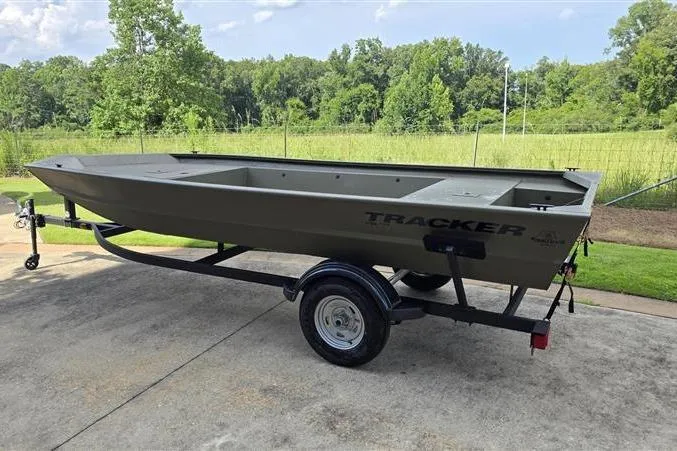Slide: The Image of 2026 Tracker Grizzly 1754 Utility boat on trailer, parked outdoors. - 2