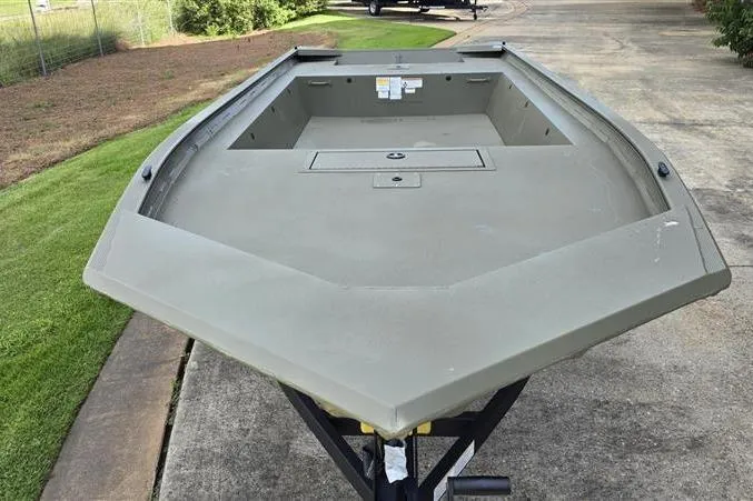 Slide: The Image of 2026 Tracker Grizzly 1754 Utility boat on trailer, parked on concrete driveway. - 5