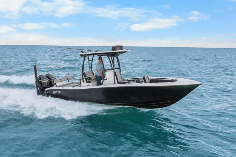 Slide: The Image of 2025 Yellowfin 26 Hybrid boat cruising on open water under a clear blue sky. - 15