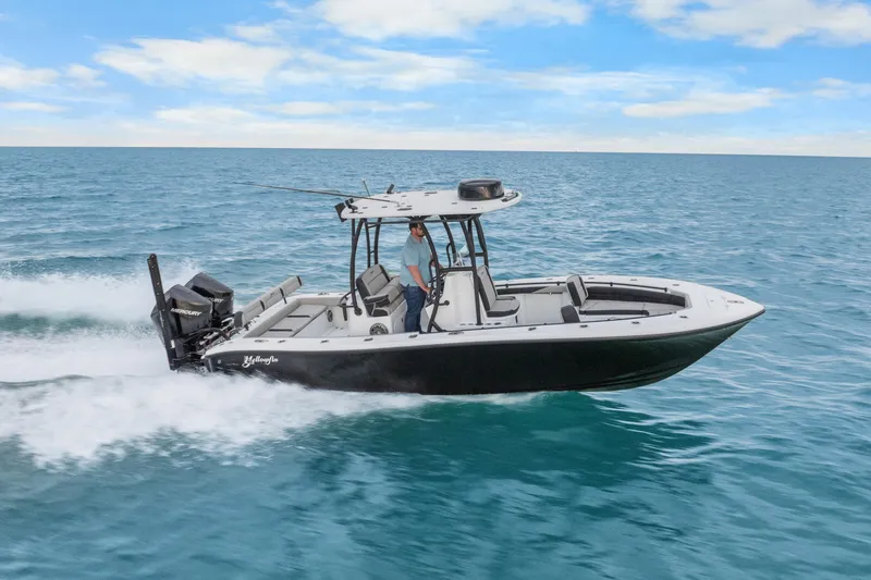 Slide: The Image of 2025 Yellowfin 26 Hybrid boat cruising on open water under a clear blue sky. - 16