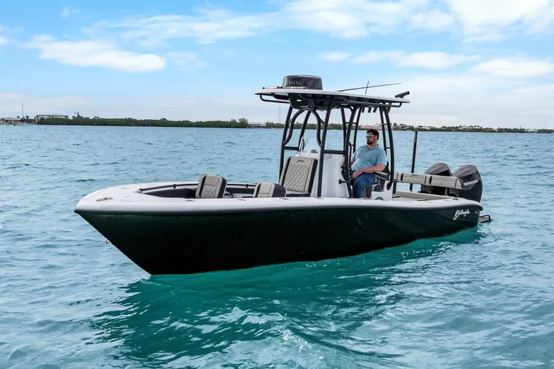Slide: The Image of 2025 Yellowfin 26 Hybrid boat on clear blue water, under a partly cloudy sky. - 3