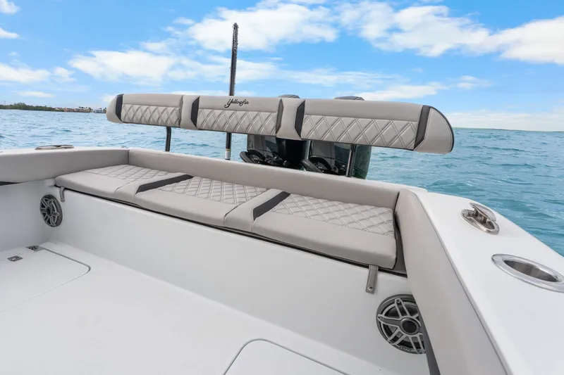 Slide: The Image of 2025 Yellowfin 26 Hybrid boat interior with cushioned seating and ocean backdrop. - 31