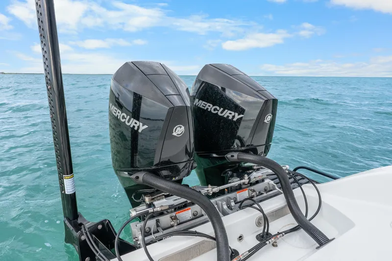 Slide: The Image of Twin Mercury outboard engines on a 2025 Yellowfin 26 Hybrid boat in open water. - 36