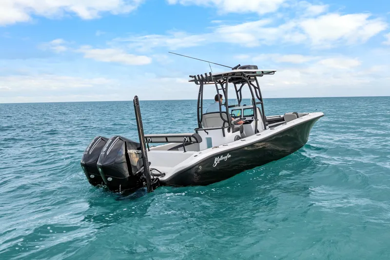 Slide: The Image of 2025 Yellowfin 26 Hybrid boat cruising on open ocean under clear blue sky. - 7