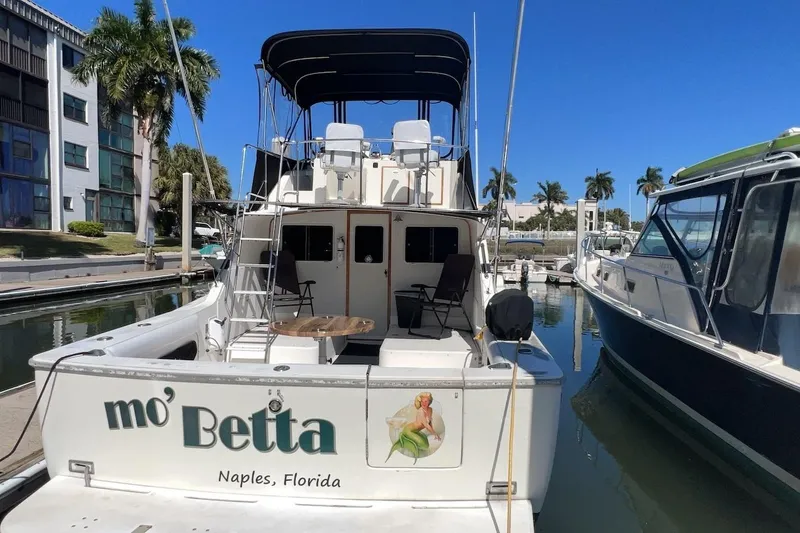 Slide: The Image of 1981 Bertram 33 Sport Fisherman docked, featuring "mo' Betta" name on the stern. - 5