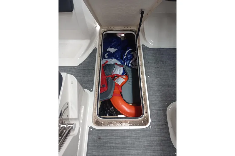 Slide: The Image of Storage compartment in 2022 Bayliner VR5 Bowrider I/O with life jacket and gear. - 14