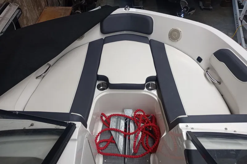 Slide: The Image of 2022 Bayliner VR5 Bowrider I/O interior with seating and red rope in storage area. - 23