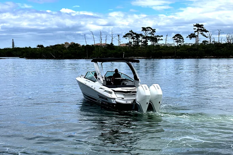 Slide: The Image of 2023 Monterey 305SS Super Sport boat cruising on a sunny waterfront. - 2