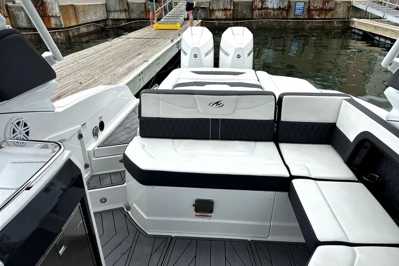 Slide: The Image of 2023 Monterey 305SS Super Sport boat with luxurious seating on a serene waterway. - 9