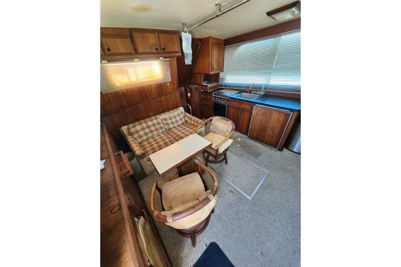 Slide: The Image of 1976 Hatterus 42 Long Range Cruiser interior with cozy seating and compact kitchen area. - 14