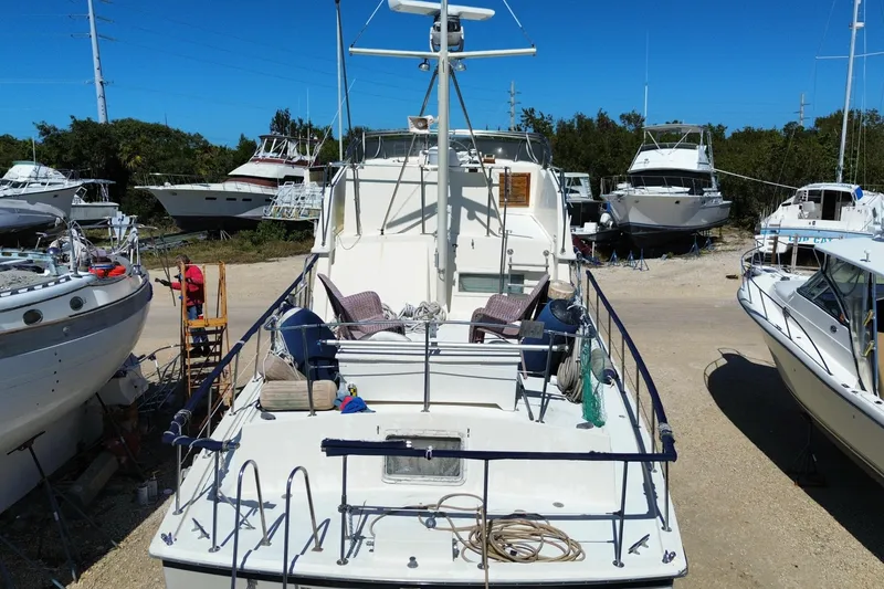 Slide: The Image of 1976 Hatterus 42 Long Range Cruiser docked among other boats under clear blue sky. - 3