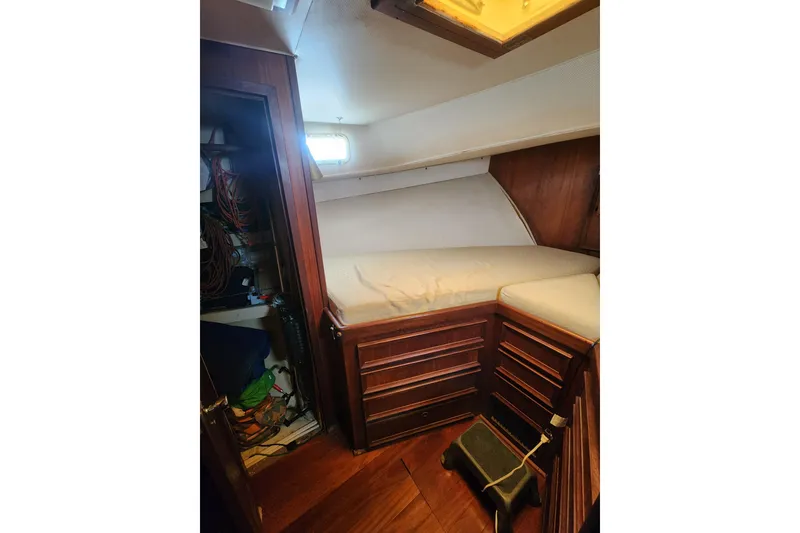 Slide: The Image of 1976 Hatterus 42 Long Range Cruiser cabin interior with wooden cabinetry and cozy sleeping area. - 9