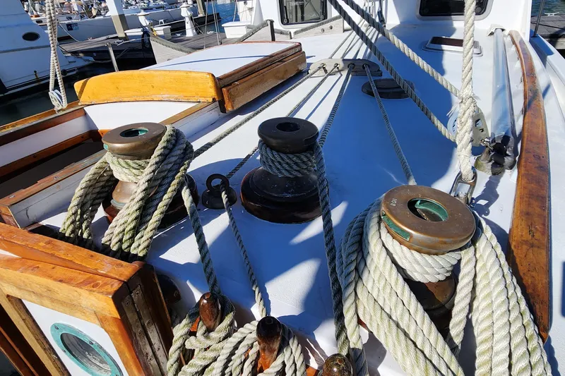 Slide: The Image of Deck of 1996 Tillotson-Pearson Motorsailer 32 with ropes and winches in a marina. - 12