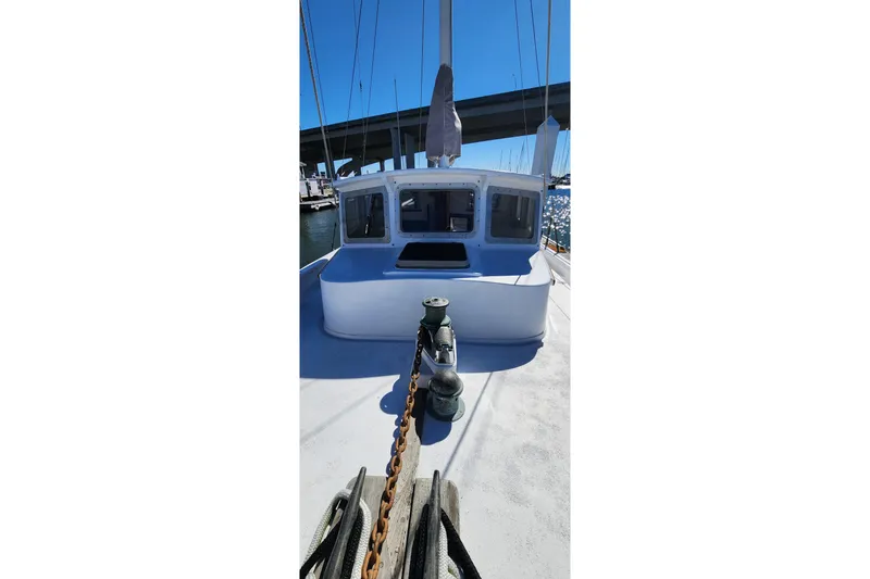 Slide: The Image of 1996 Tillotson-Pearson Motorsailer 32 on water, showcasing deck and cabin under clear blue sky. - 18