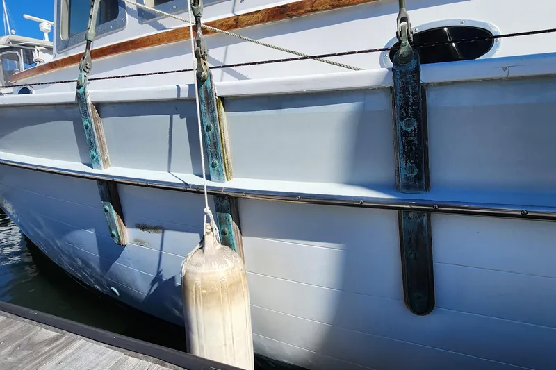 Slide: The Image of 1996 Tillotson-Pearson Motorsailer 32 docked, showing hull details and fender. - 21