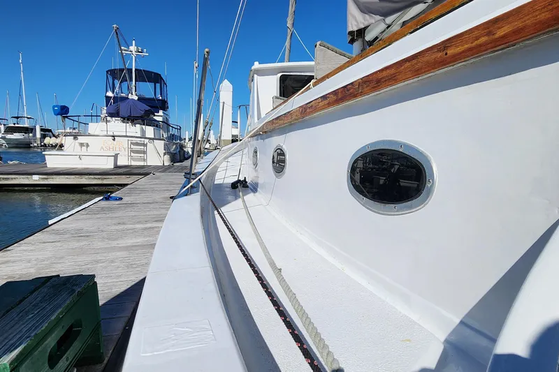 Slide: The Image of 1996 Tillotson-Pearson Motorsailer 32 docked at marina under clear blue sky. - 22