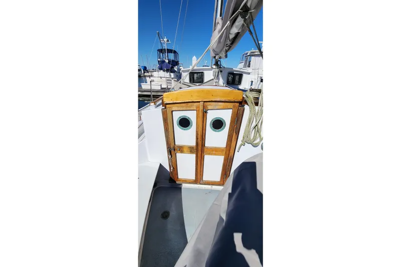 Slide: The Image of 1996 Tillotson-Pearson Motorsailer 32 with wooden cabin doors and nautical ropes. - 23