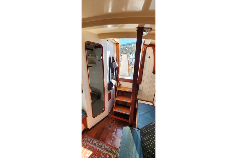 Slide: The Image of Interior of 1996 Tillotson-Pearson Motorsailer 32 with wooden stairs and mirror. - 29