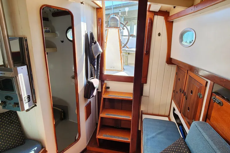 Slide: The Image of Interior of a 1996 Tillotson-Pearson Motorsailer 32, featuring wooden stairs and nautical decor. - 30