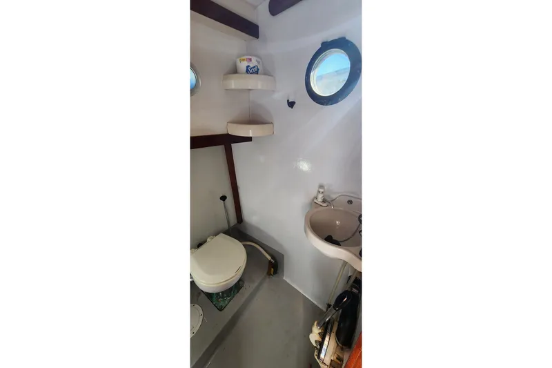 Slide: The Image of Bathroom interior of 1996 Tillotson-Pearson Motorsailer 32 with toilet, sink, and porthole. - 31