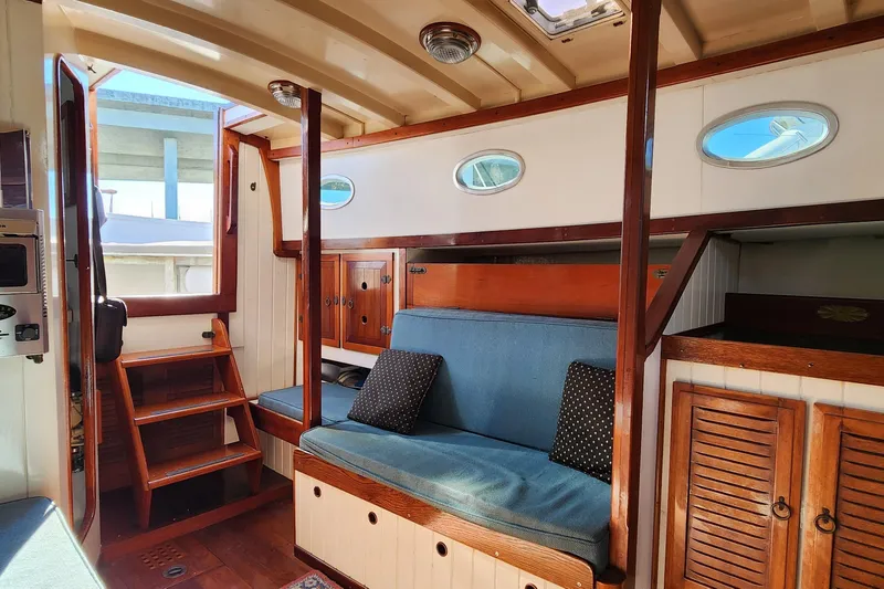 Slide: The Image of Interior of 1996 Tillotson-Pearson Motorsailer 32 with wooden finishes and blue seating. - 35