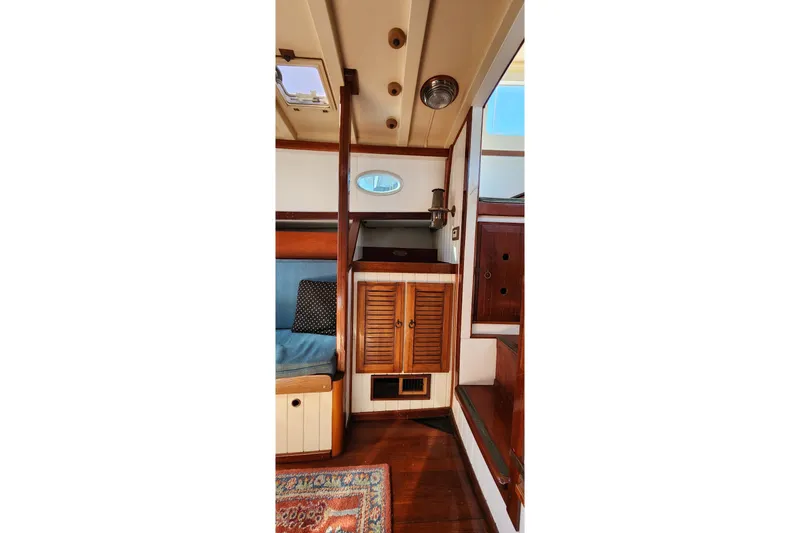 Slide: The Image of Interior of 1996 Tillotson-Pearson Motorsailer 32, featuring wooden cabinetry and seating area. - 37