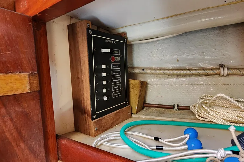 Slide: The Image of Electrical panel inside 1996 Tillotson-Pearson Motorsailer 32, featuring switches and wiring. - 38