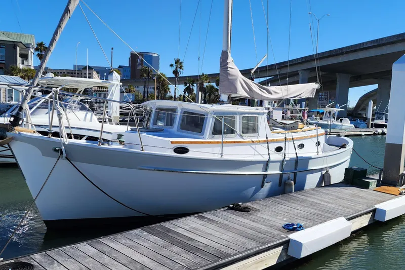 Slide: The Image of 1996 Tillotson-Pearson Motorsailer 32 docked at marina under clear blue sky. - 4
