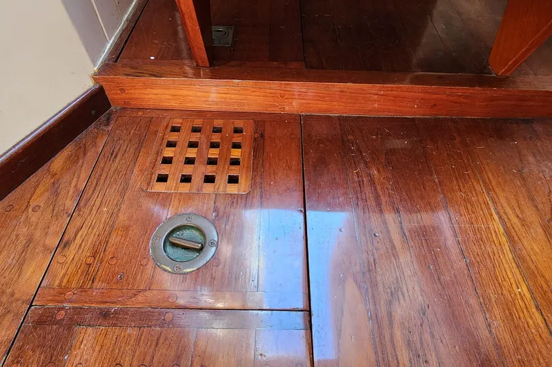 Slide: The Image of Polished wooden floor of 1996 Tillotson-Pearson Motorsailer 32, featuring a vent and hatch. - 40