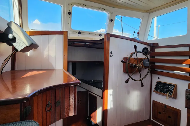 Slide: The Image of Interior of 1996 Tillotson-Pearson Motorsailer 32, featuring wooden helm and nautical decor. - 41