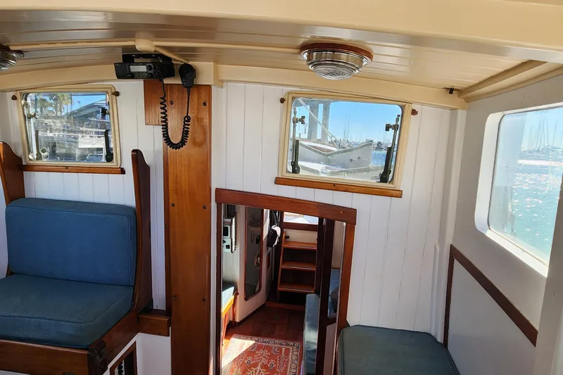 Slide: The Image of Interior of a 1996 Tillotson-Pearson Motorsailer 32, featuring wooden accents and blue seating. - 44