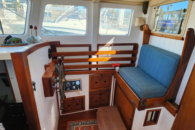 Slide: The Image of Cozy interior of 1996 Tillotson-Pearson Motorsailer 32 with wooden helm and blue cushioned seat. - 46