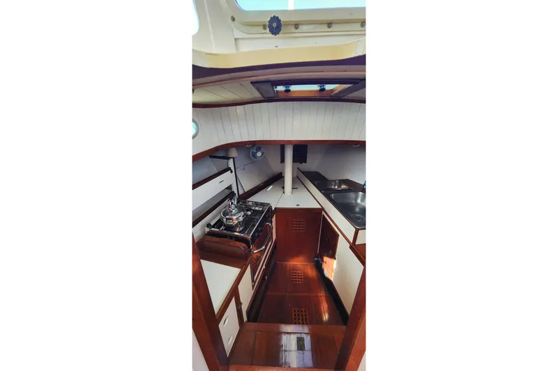 Slide: The Image of Interior of 1996 Tillotson-Pearson Motorsailer 32, featuring a compact kitchen area. - 51