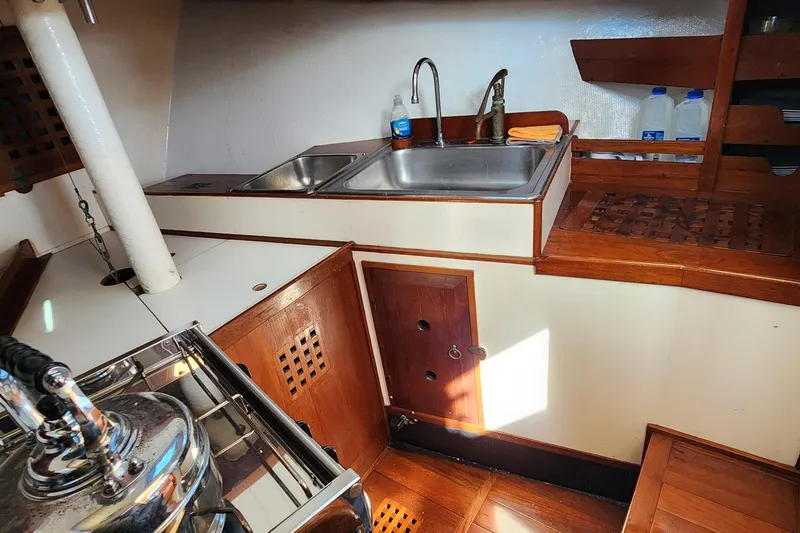Slide: The Image of 1996 Tillotson-Pearson Motorsailer 32 interior kitchen with sink and wooden cabinetry. - 53