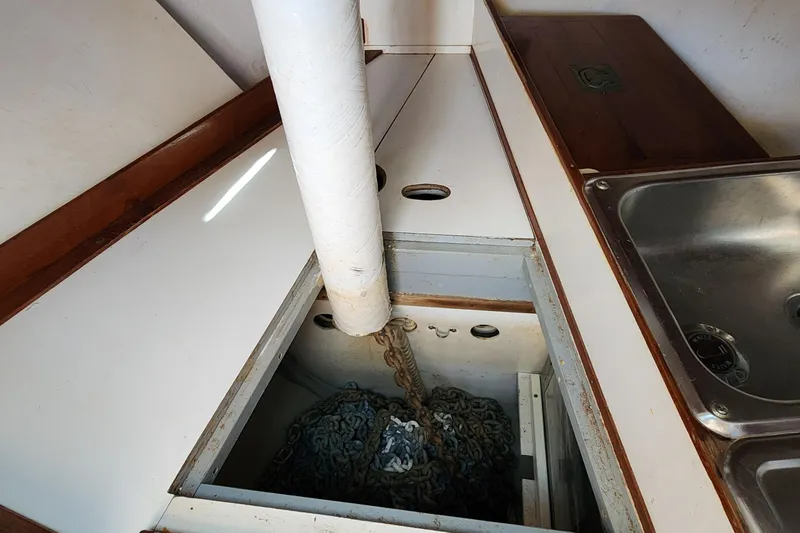 Slide: The Image of Anchor chain storage in 1996 Tillotson-Pearson Motorsailer 32, near kitchen sink area. - 55