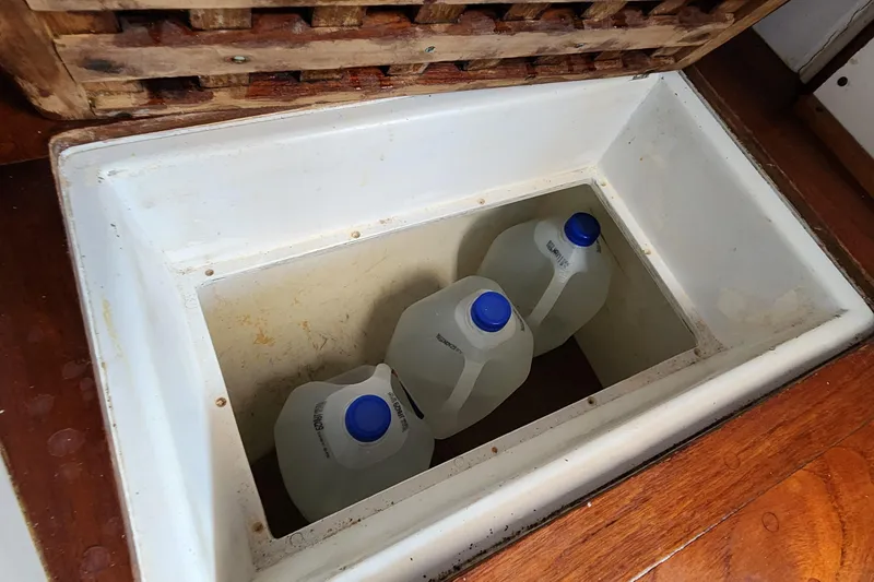 Slide: The Image of Storage compartment with water jugs on a 1996 Tillotson-Pearson Motorsailer 32 boat. - 56