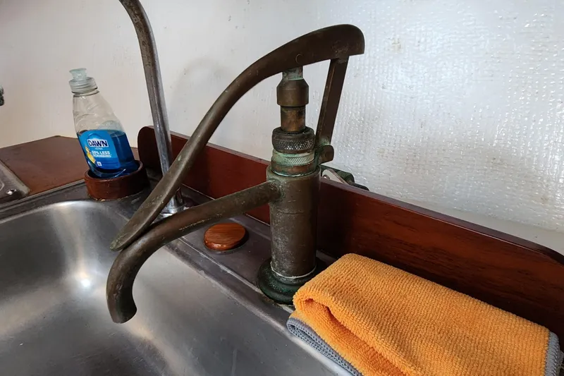 Slide: The Image of Vintage pump faucet in 1996 Tillotson-Pearson Motorsailer 32 kitchen, with soap and towel nearby. - 60