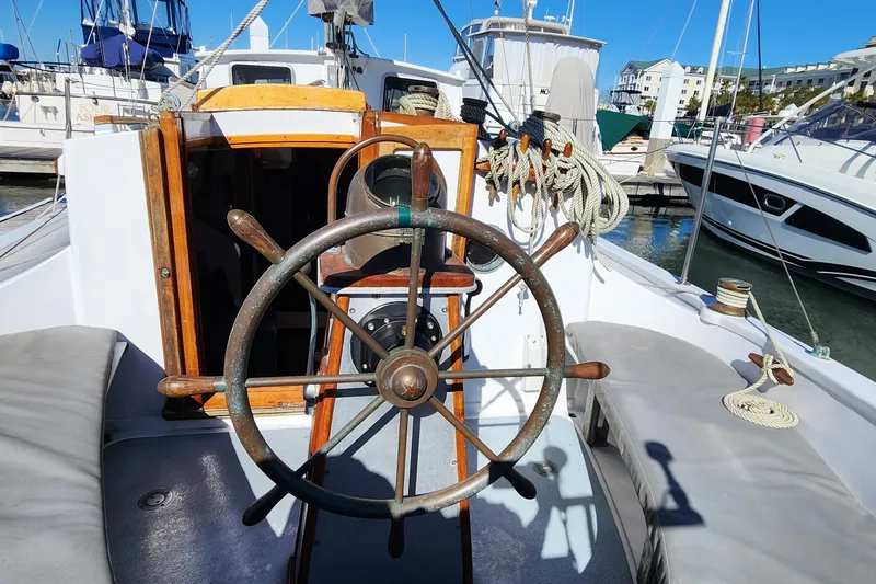 Slide: The Image of 1996 Tillotson-Pearson Motorsailer 32 cockpit with wooden wheel and nautical ropes. - 8