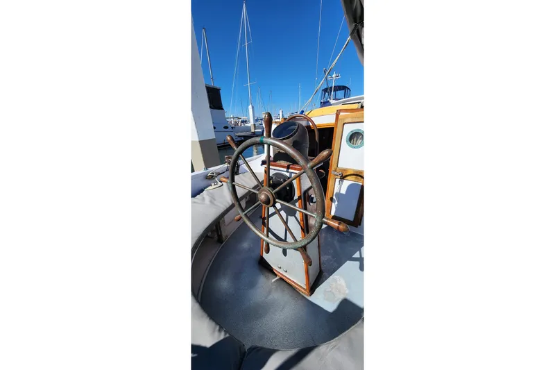 Slide: The Image of Steering wheel of 1996 Tillotson-Pearson Motorsailer 32, docked with other boats. - 9