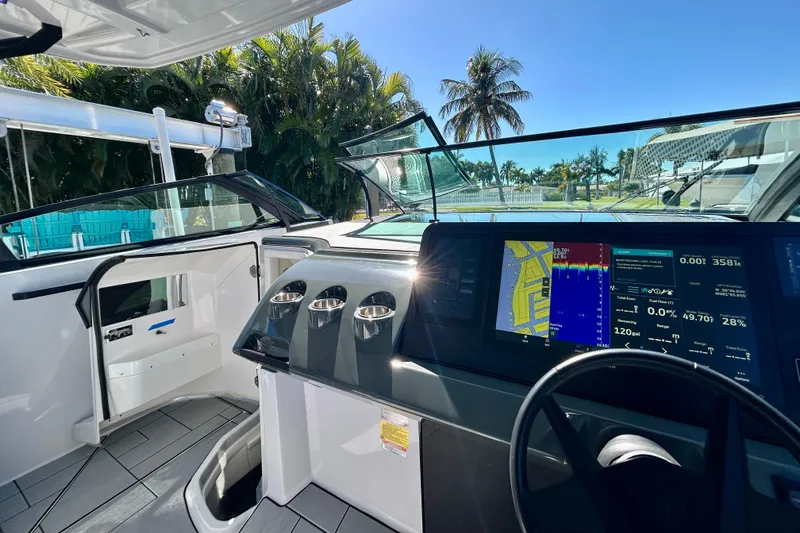 Slide: The Image of 2022 Aviara AV40 OB boat cockpit with advanced navigation screens and tropical background. - 34