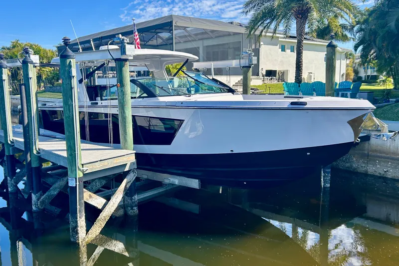 Slide: The Image of 2022 Aviara AV40 OB boat docked by waterfront with palm trees and clear sky. - 4