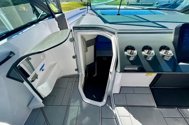 Slide: The Image of 2022 Aviara AV40 OB boat interior with open cabin door and sleek dashboard design. - 45