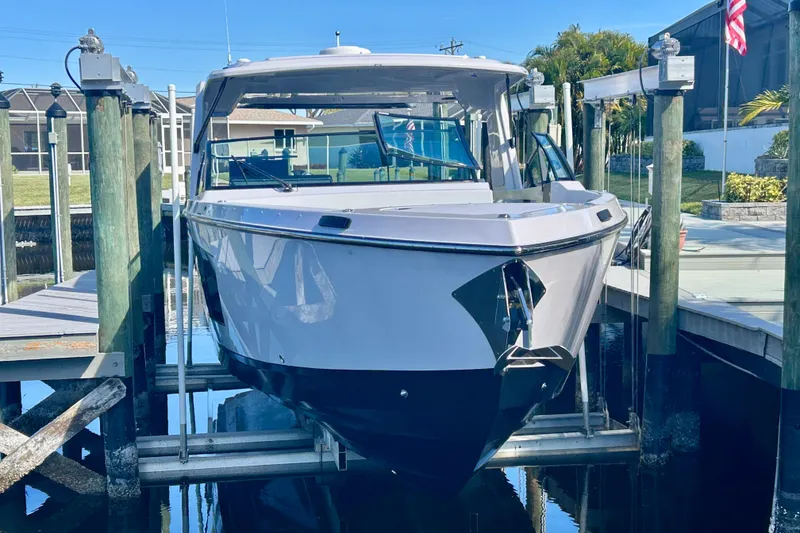 Slide: The Image of 2022 Aviara AV40 OB boat docked on a lift, surrounded by wooden piers. - 5