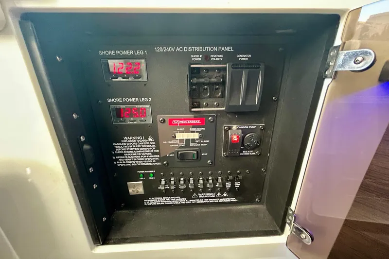 Slide: The Image of 2022 Aviara AV40 OB electrical distribution panel with voltage readings and control switches. - 58