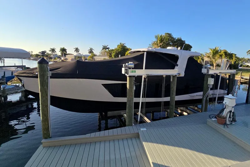 Slide: The Image of 2022 Aviara AV40 OB boat docked with cover, surrounded by palm trees. - 62