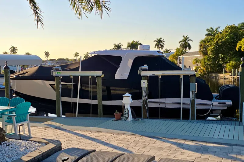 Slide: The Image of 2022 Aviara AV40 OB boat docked, covered, surrounded by palm trees and patio furniture. - 63