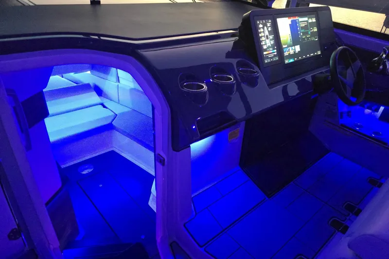 Slide: The Image of 2022 Aviara AV40 OB boat interior with blue LED lighting and modern dashboard. - 68