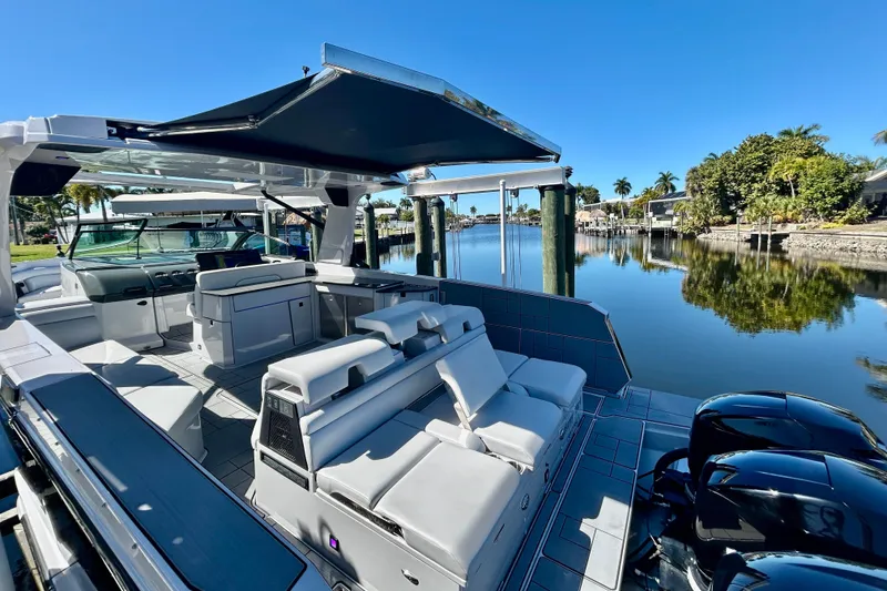 Slide: The Image of 2022 Aviara AV40 OB luxury boat with spacious seating on a serene waterfront. - 9