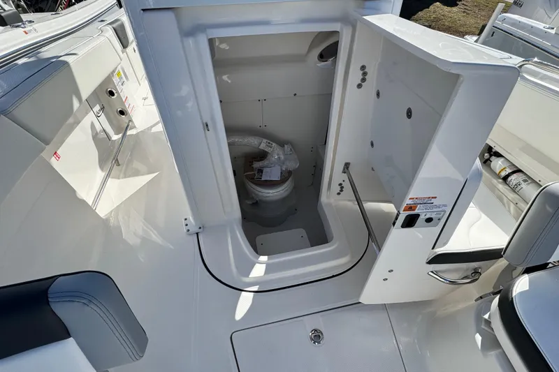 Slide: The Image of 2026 Robalo R250 Center Console boat interior with open marine toilet compartment. - 10