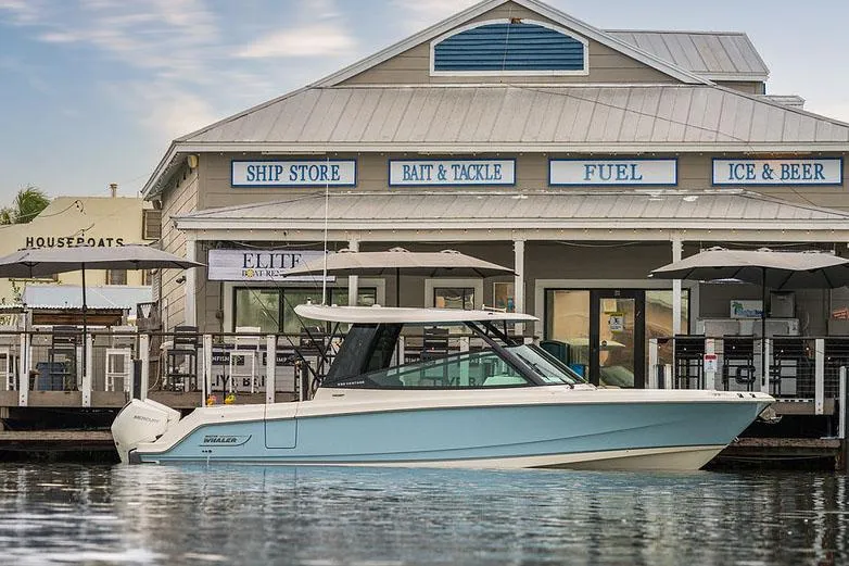 The Image of Manufacturer Provided Image: 2025 Boston Whaler 330 Vantage docked near a marina store. - 0